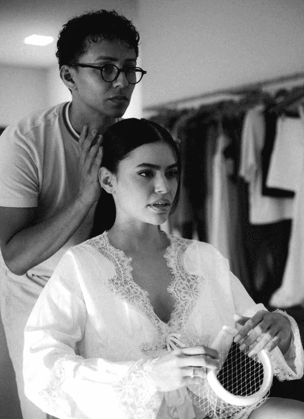 Profissional da equipe finalizando o penteado de uma noiva